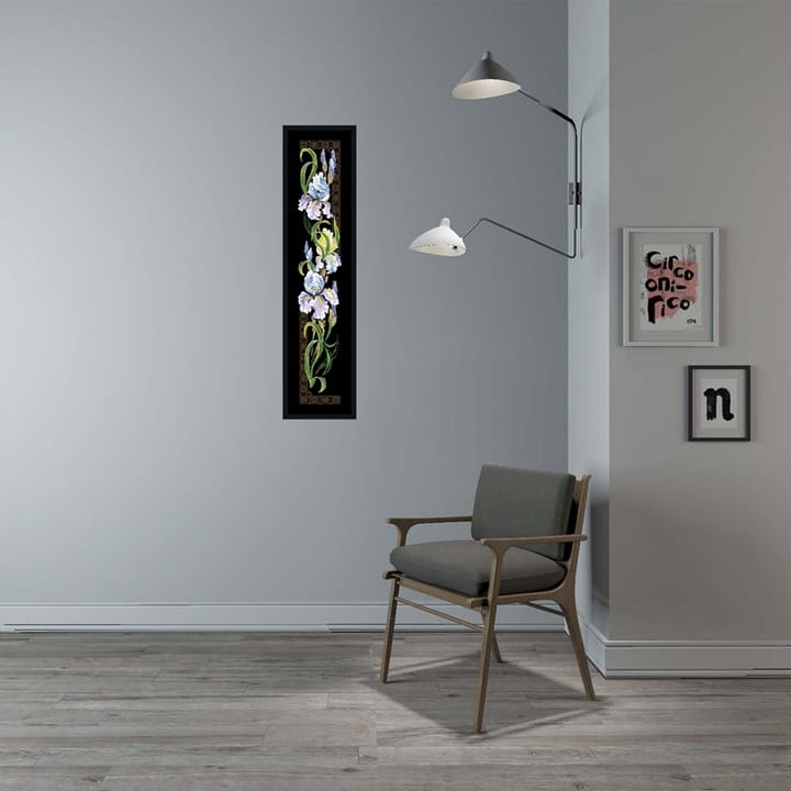 Framed iris cross stitch panel on a gray wall beside a chair